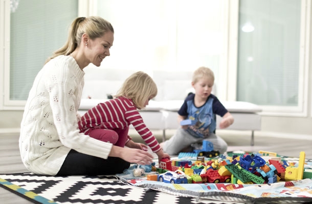 Laura Nurmi leikkii kahden lapsensa kanssa legoilla.