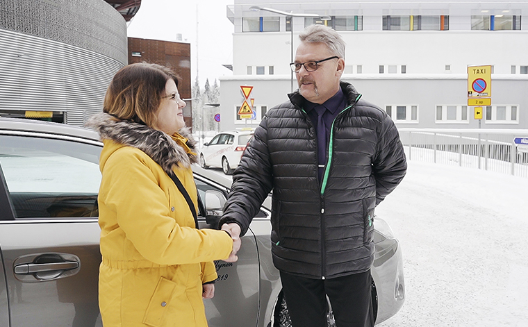 Anne Markkanen ja taksinkuljettaja Veli Myllynen kättelevät sairaalan pihalla.