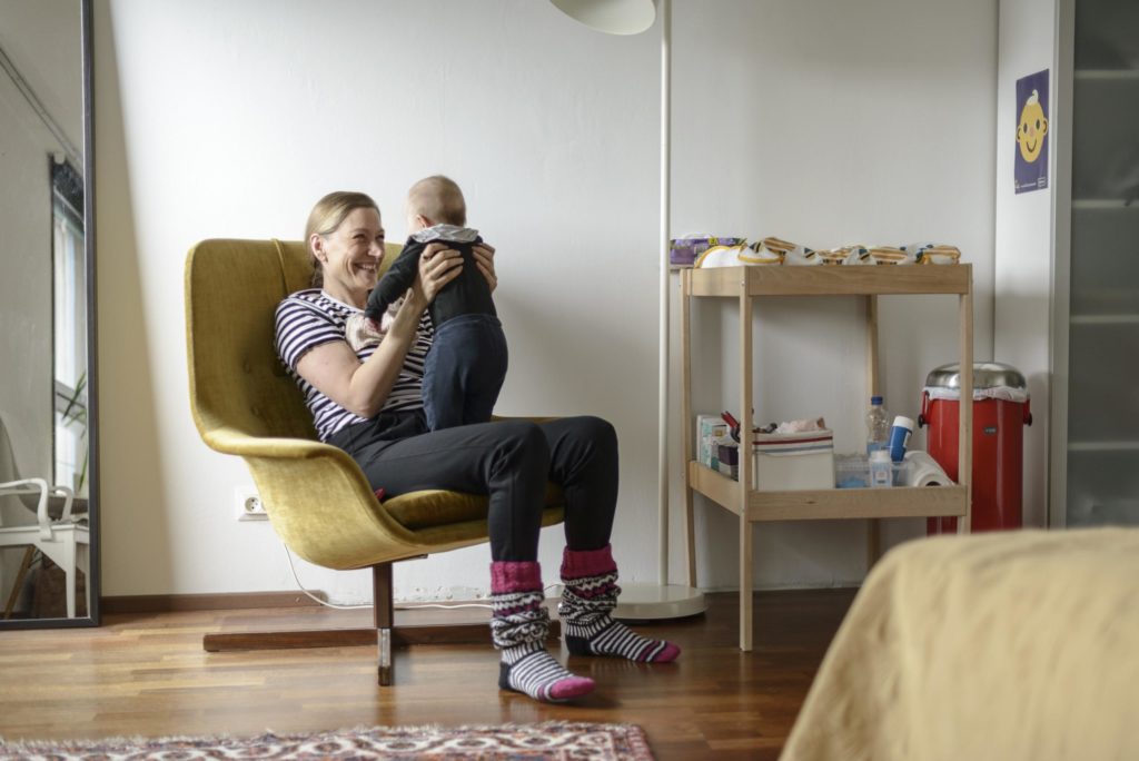 Merja Mähkä leikittää vauvaansa nojatuolissa. 