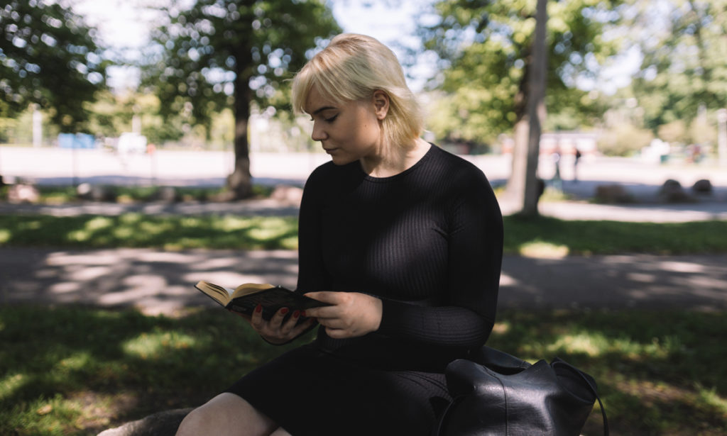 MMira lukee kirjaa puistossa. 