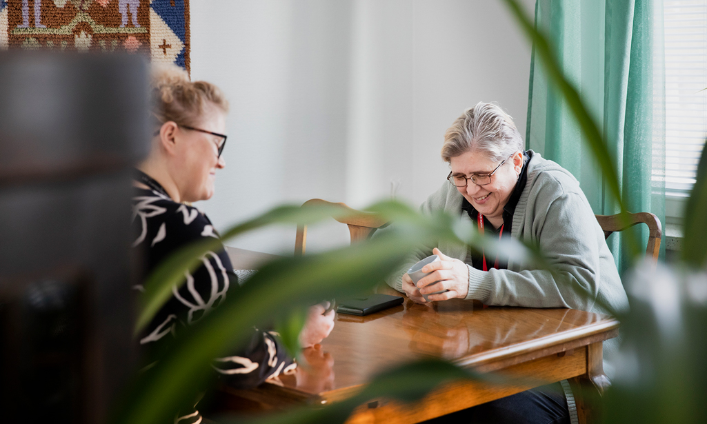 Aulis chef Jonna Schadewitz-Laakkonen och Auli sitter vid ett bord med varsin kaffekopp.