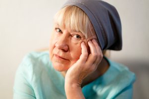 Tuula stöder sig mot handen och tittar in i kameran.