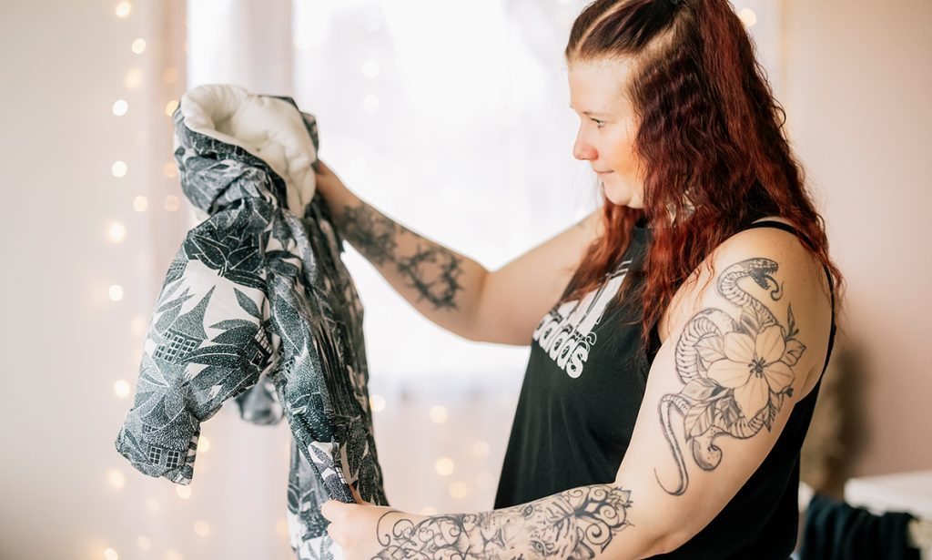 Jenni undersöker overallen i moderskapsförpackningen.