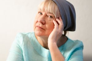 Tuula nojaa käteensä ja katsoo kameraan.