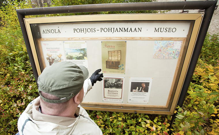 Sami Pohjois-Pohjanmaan museon ilmoitustaulun edessä.