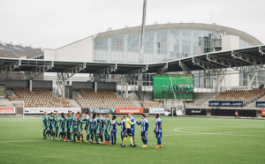 Jalkapallojoukkueet kättelevät toisiaan stadionilla.