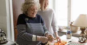 Kuvituskuva. Mummo ja tyttö pilkkovat juureksia keittoon.
