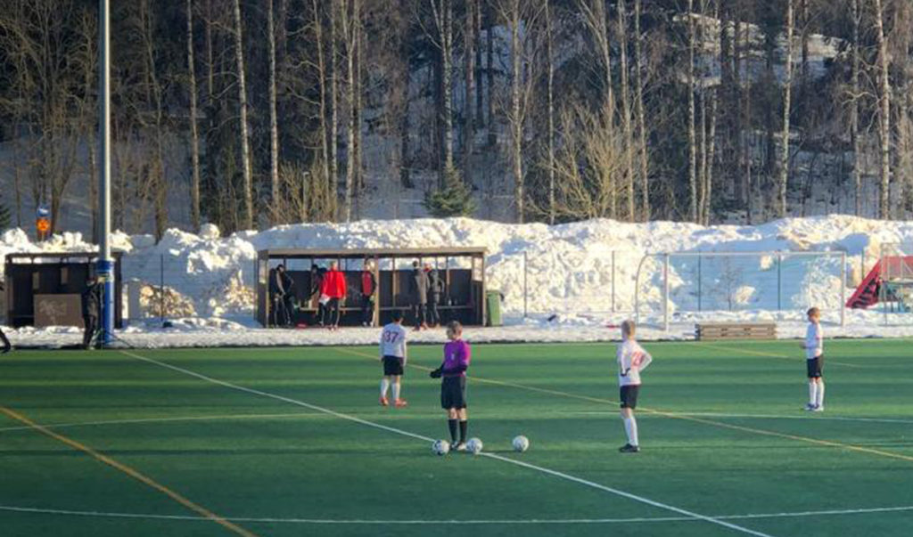 På fotbollsplanen står fyra spelare.