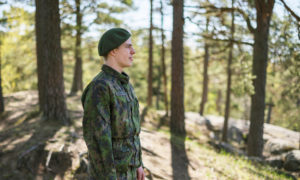 Joona står utomhus, bakom syns tallar.