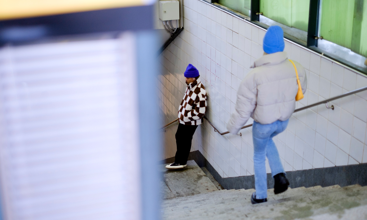 En ung kvinna går ner för trappan på stationen.