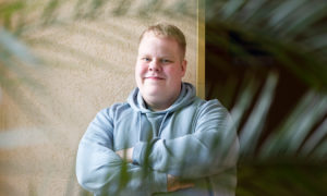 Niko står med armarna i kors och ler mot kameran.