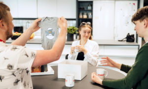 Jani Tikka iakttar den babybody som han fått som gåva vid köksbordet på sin arbetsplats.