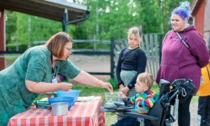 Puheterapeutti Lotta ojentaa Joonatanille leikkiostoksen.