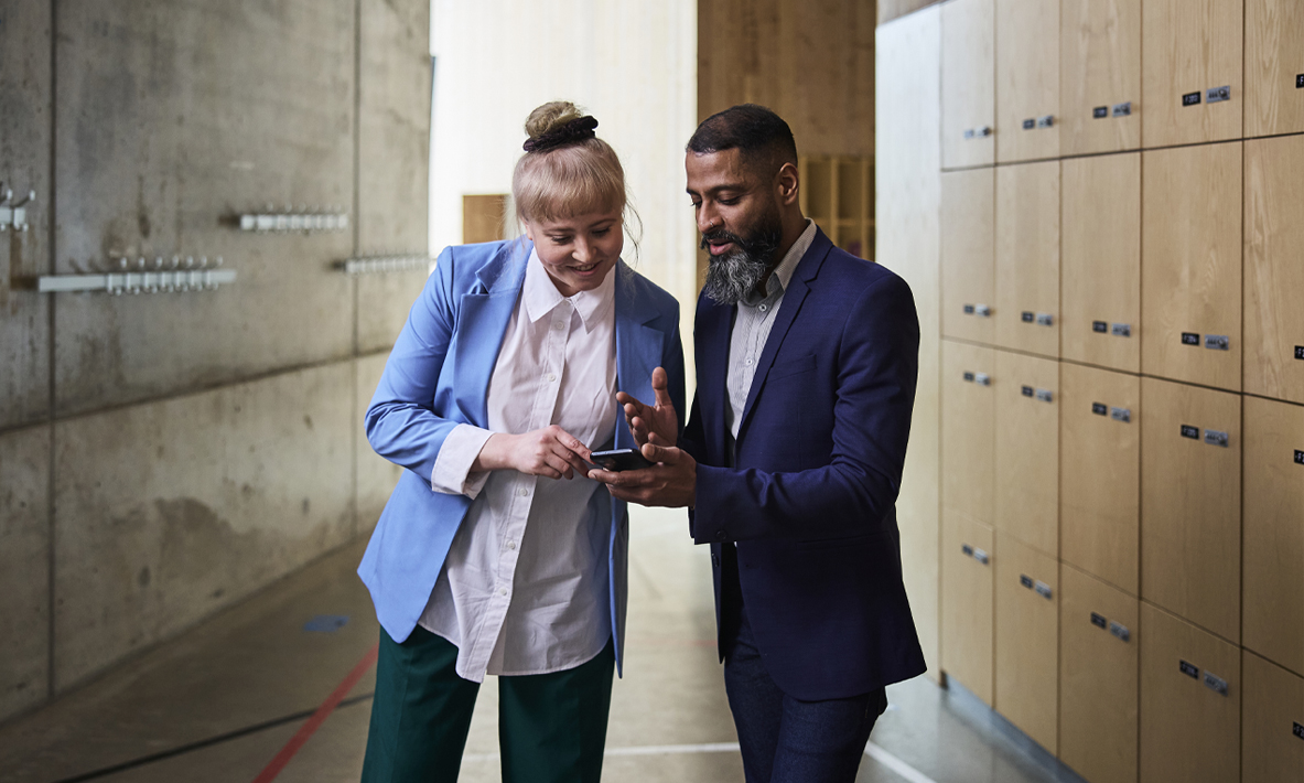 två personer tittar på smartphone.