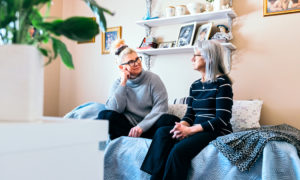 Marika Lintala och hennes mamma Aino Mylläri sitter på soffan.