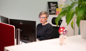 Sanna Hughes istuu toimistossa koneen äärellä ja työskentelee.