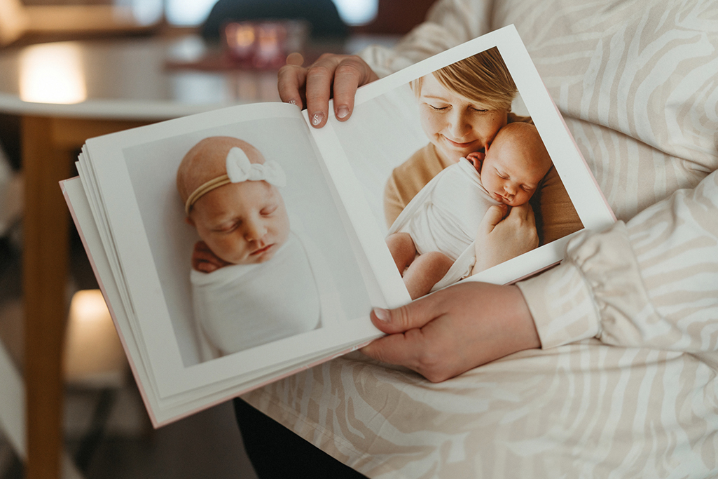 Tytti håller i ett fotoalbum med bilder på hennes dotter som nyfödd. 