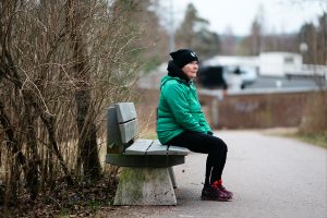Rauni sitter på en parkbänk.