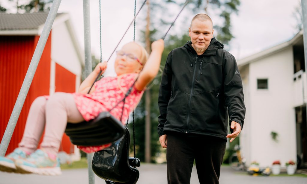 Janin tytär keinuu ja Jani antaa vauhtia. 