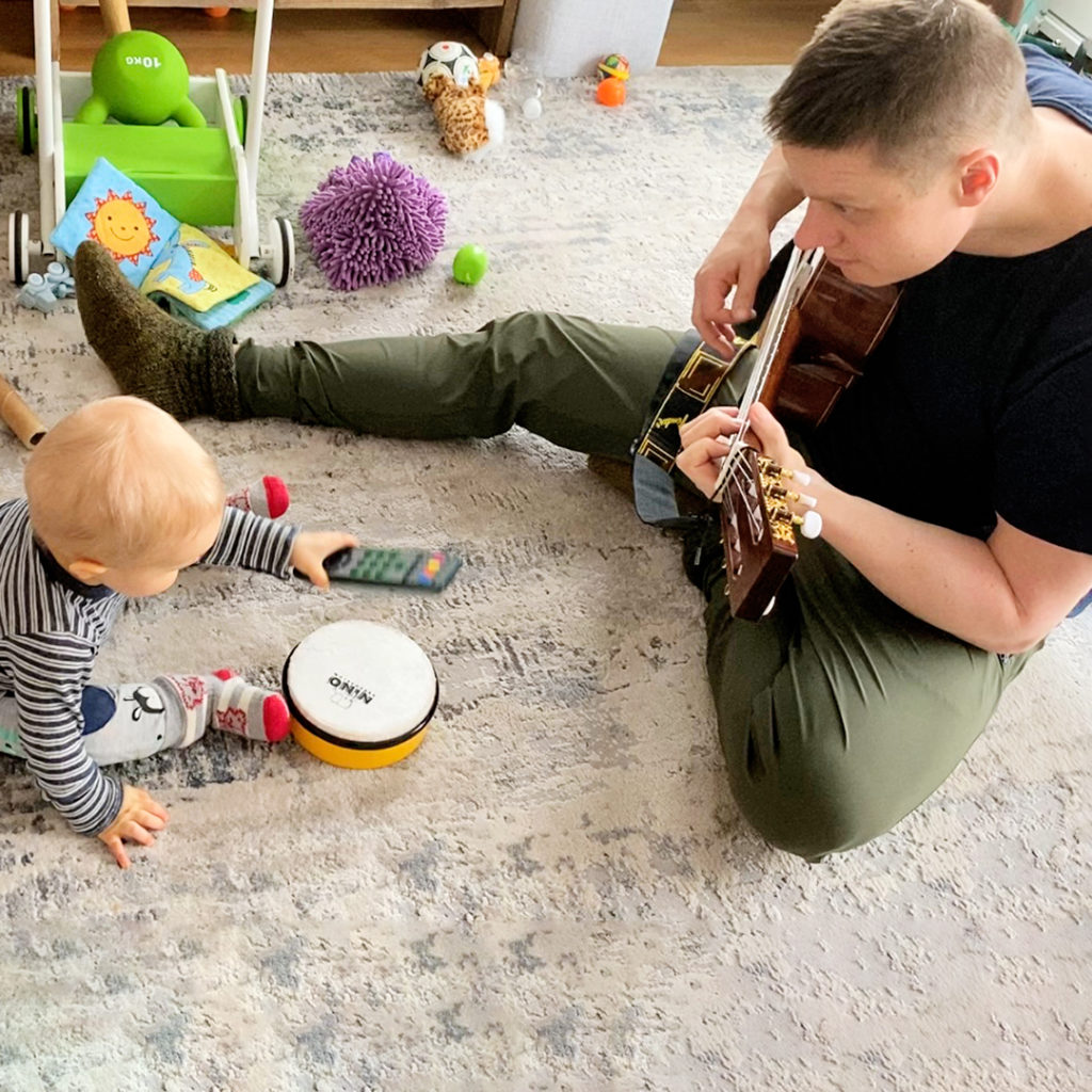 Isä ja poika soittavat soittimia lattialla.