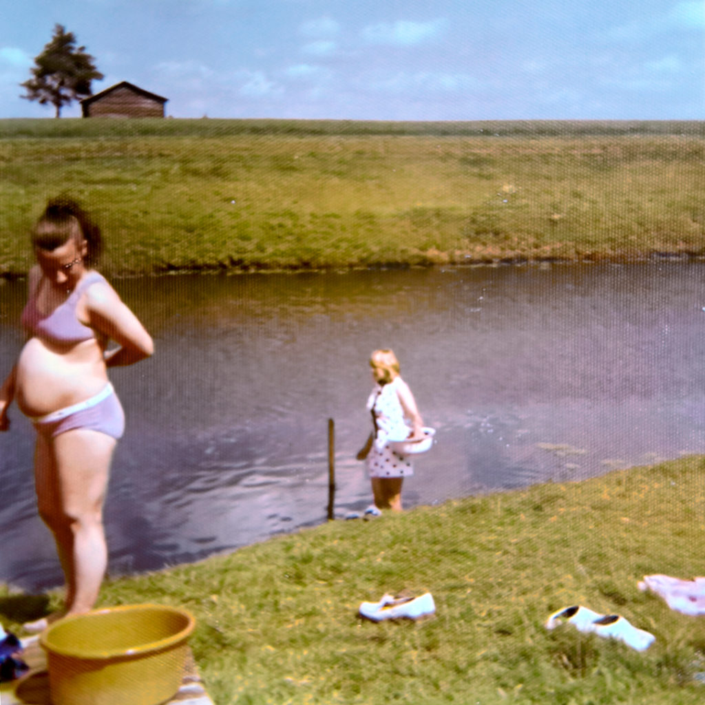 Aino Mylläri seisoo kesällä ulkona joen äärellä. Hän on raskaana.