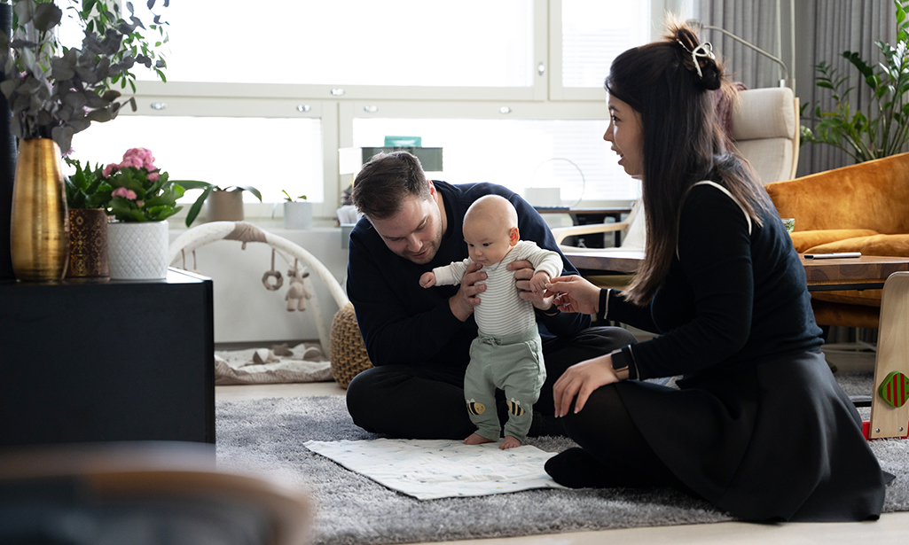 Jens och Yan sitter på golvet och leker med Lukas. 